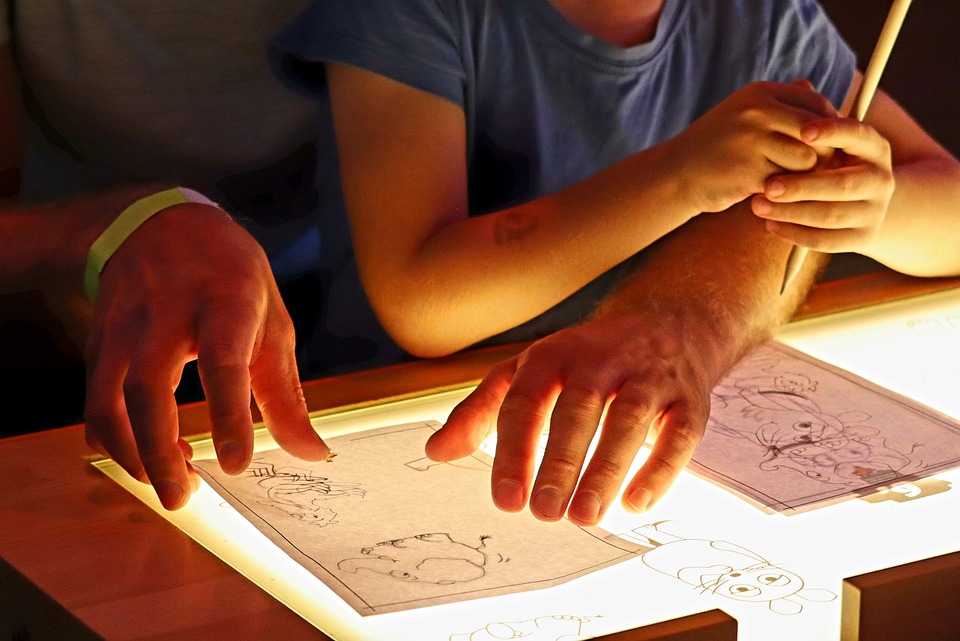 Animators working on character drawings on an light box desk