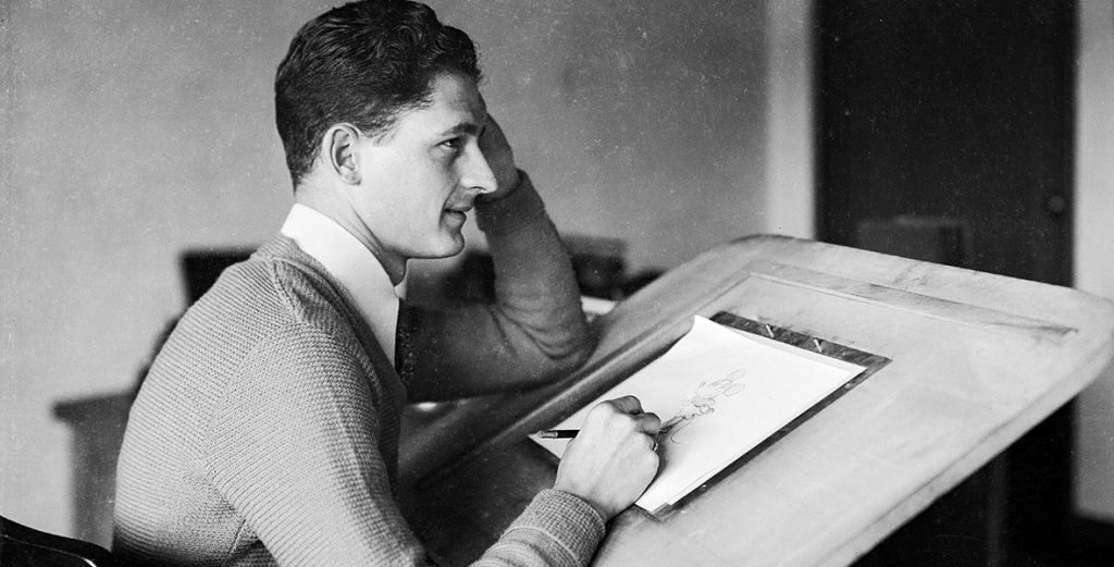 Black and white photograph of Les Clark at his drawing board
