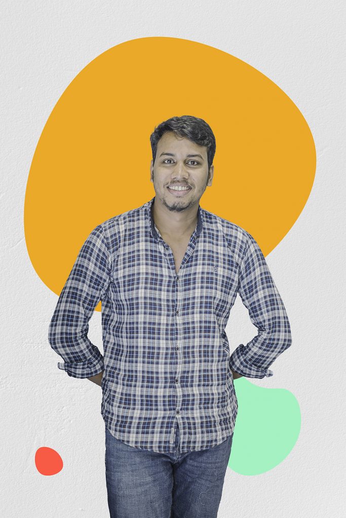 Image of Salman Alam standing with his hands behind his back on a graphic background with red yellow and green circle shapes