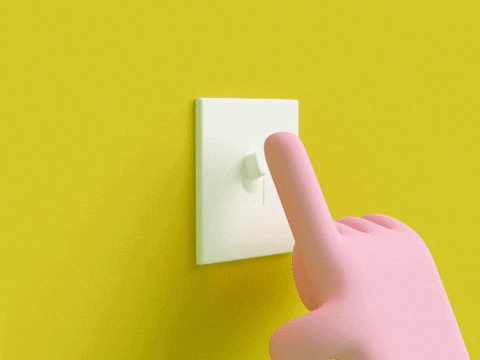 a hand flicking a light switch on and off on a yellow wall